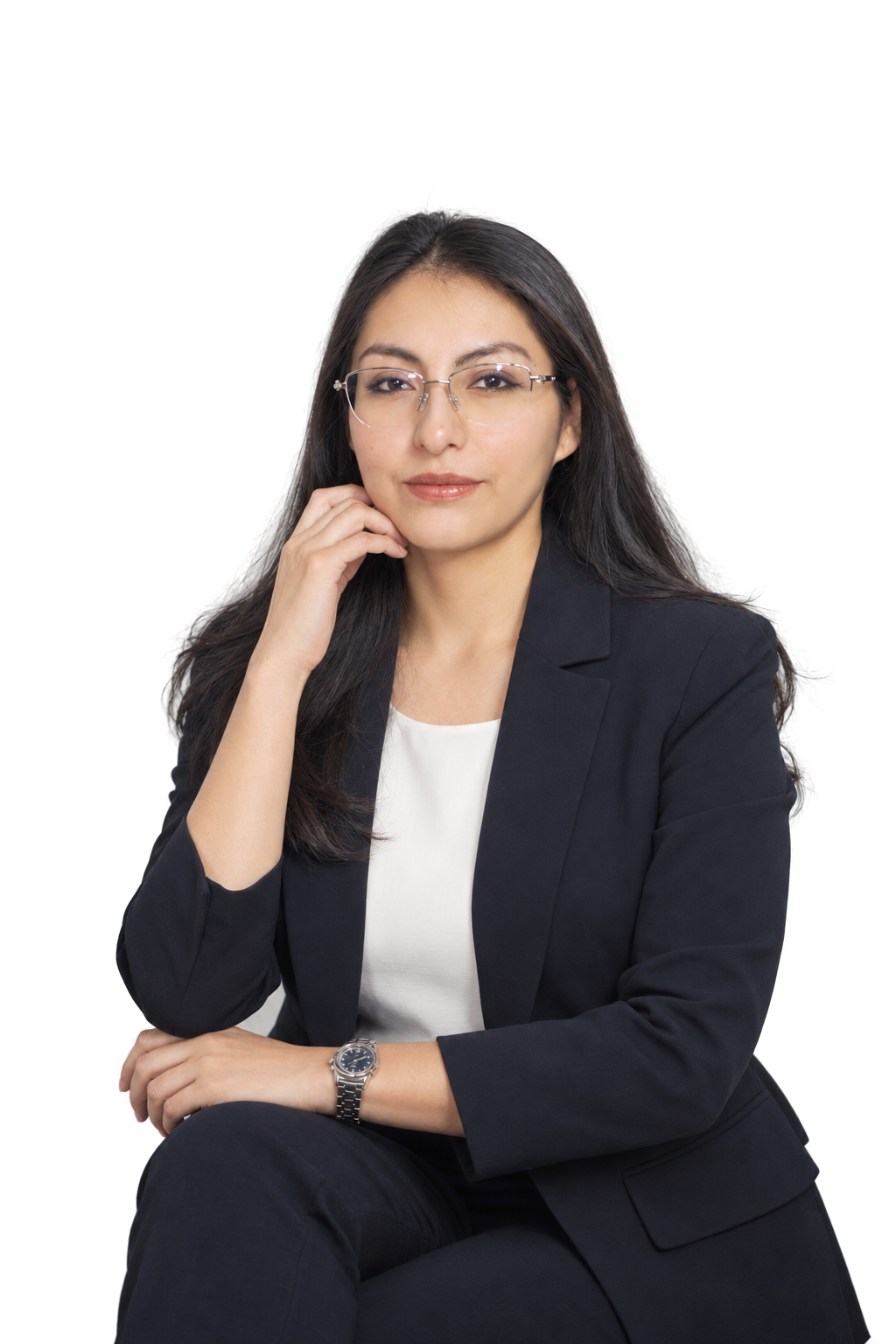 Angie Nuñez sentada, con lentes, blazer azul oscuro y blusa blanca.